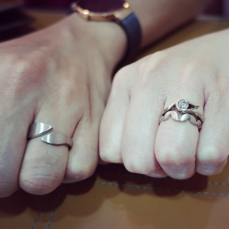Hands wearing engagement and wedding rings